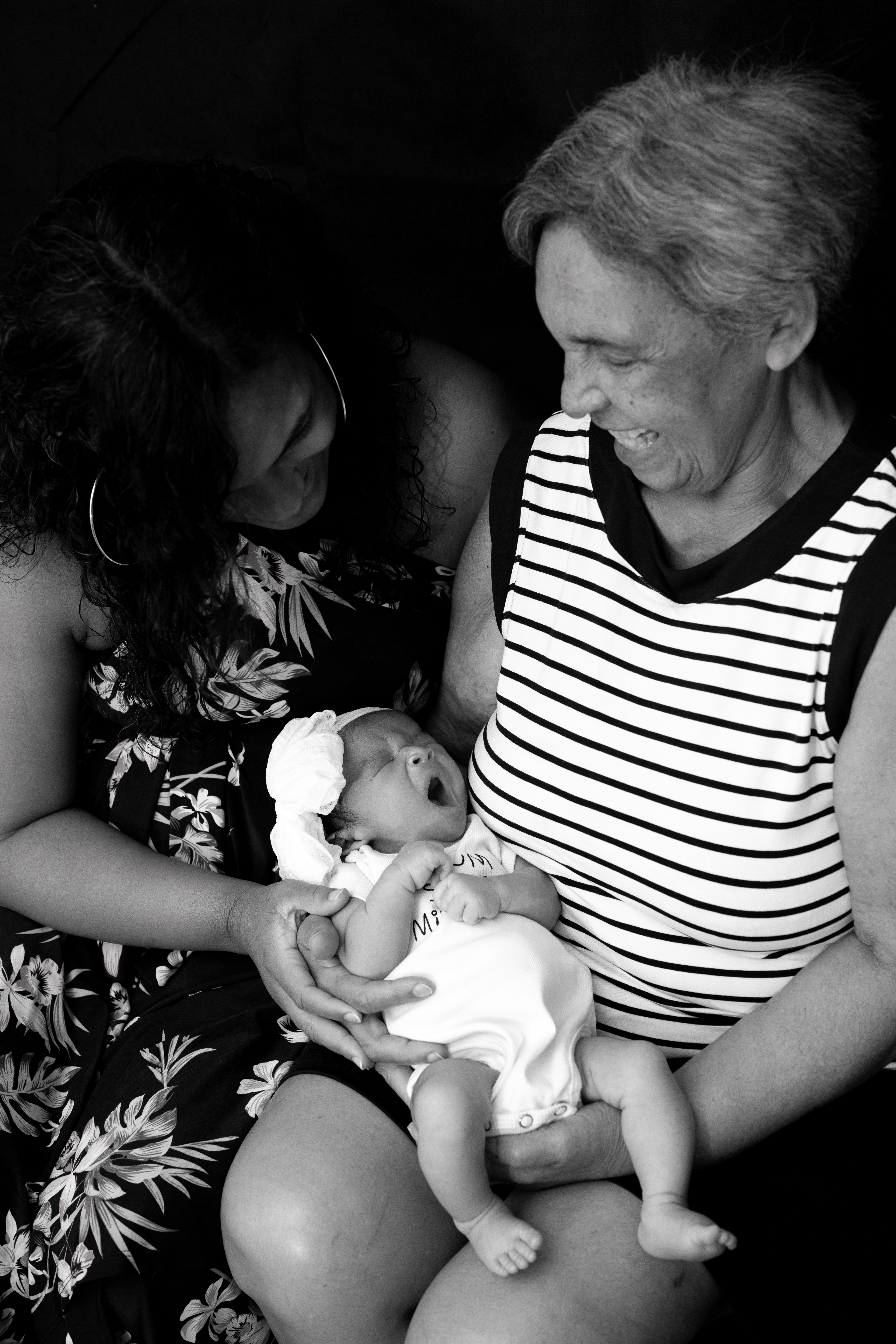 Three generations admiring a newborn together